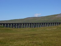 DSC02250  The Ribblehead Viaduct carries the Settle-Carlisle Railway across the valley of the River Ribble. The first stone was laid on 12 October 1870 and it was opened in 1875. It is reputed to have cost 200 lives from diseases and accidents. The viaduct is 440 yards (400 m) long, and 104 feet (32 m) above the valley floor at its highest point. It has 24 spans. British Rail attempted to close the line in the 1980s. The closure proposals generated tremendous protest and were eventually retracted. The line is now in regular use and it is also a popular destination for steam specials. (Click the pin at the upper right corner of the text box to see the viaduct's location)